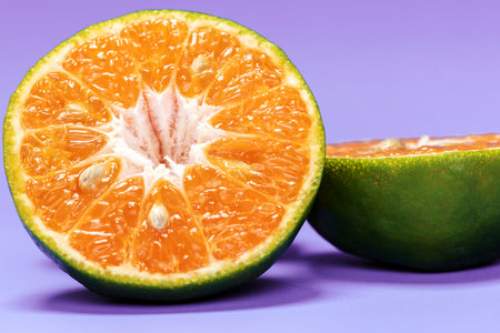 Close-up ,The Orange fruit  on purple backdrop.The fruit have many vitamin C. Macro photo fresh...