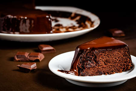 Chocolate cake slice in the white plate on the table. Close-up tasty homemade cakeの写真素材