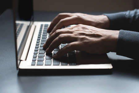 Close up of person hand typing on laptop keyboard, author useing internet on notebook computer ,Side...