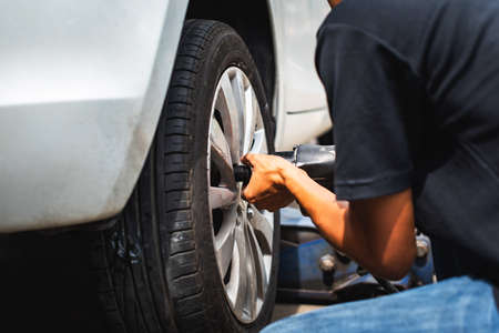 The technician doing assembling car wheel after finish repaired tire,tighten the nutの写真素材