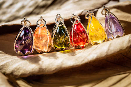 The many color gemstone pendant with silver frame on leaf background.Vintage  pendant ,used for vintage fashion backgroundの写真素材