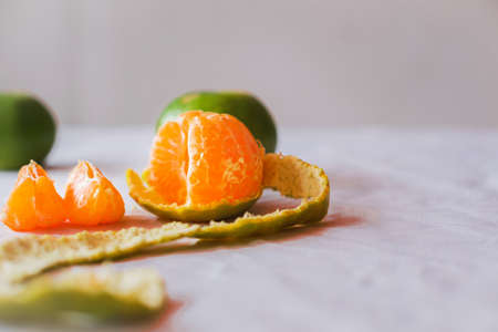 Close-up ,The oranges  on the  table on white backdrop .The oranges have green peel . The fruit have many vitamin C,peeling orangeの写真素材