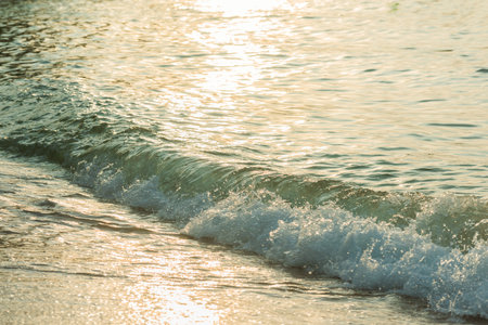 Wave on sandy beach in the sunset.use to background