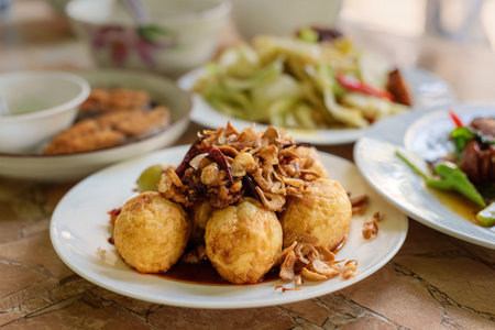 Boiled Eggs and bring to fried seasoned  in the plate for breakfast or lunch or diner,the food are boiled eggs ,onion ,chili and garlic mixed together by heat,some menu on food tableの写真素材