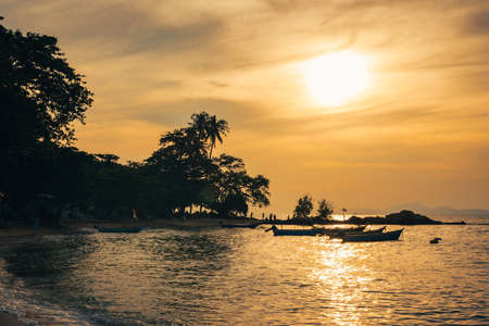 View of fishing boats moored on the seashore in the twilight, backlit photography,golden light,background landscape of the sea in eveningの写真素材