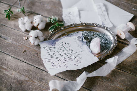 Graphic arts of beautiful wedding calligraphy cards and silver plate with two wedding ring on wood background.の写真素材