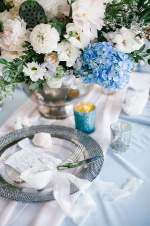 Graphic arts of beautiful wedding calligraphy cards and silver plate with cutlery on festive wedding table. の写真素材
