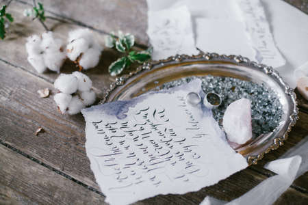 Graphic arts of beautiful wedding calligraphy cards and silver plate with two wedding ring on wood background.の写真素材