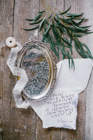 Graphic arts of beautiful wedding calligraphy cards and silver plate with silk ribbon on wood background.の写真素材