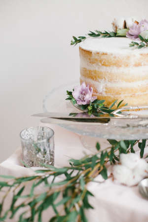 Beautiful wedding round cake with floral decorations on glass cake stand.の写真素材