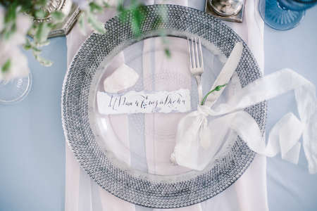 Graphic arts of beautiful wedding calligraphy cards and silver plate with cutlery on festive wedding table.の写真素材