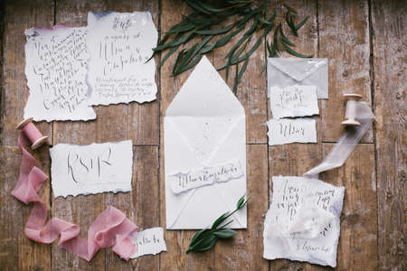 Graphic arts of beautiful wedding calligraphy cards with flower and chiffon bobbins on wood background.の写真素材