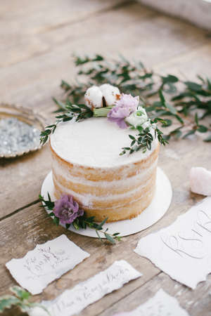 Graphic arts of beautiful wedding calligraphy cards and round cake with floral decorations on wood background.の写真素材