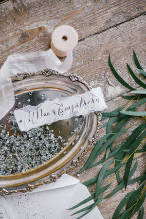 Graphic arts of beautiful wedding calligraphy cards and silver plate with silk ribbon on wood background.の写真素材