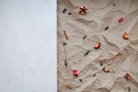 Wrinkled brown kraft paper and dry flowers pattern background.の写真素材