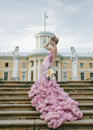 Bridal Fashion. Portrait of young beautiful modern bride with stylish make-up and and hairdo in mermaid style wedding pink dress.の写真素材