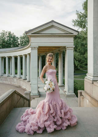 Bridal Fashion. Portrait of young beautiful modern bride with stylish make-up and and hairdo in mermaid style wedding pink dress.の写真素材
