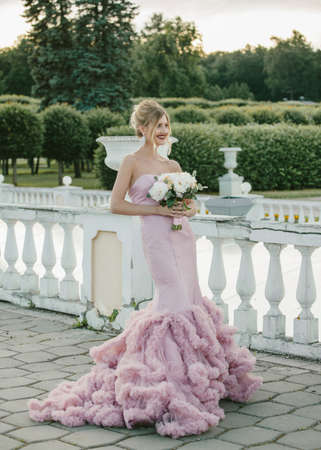 Bridal Fashion. Portrait of young beautiful modern bride with stylish make-up and and hairdo in mermaid style wedding pink dress.の写真素材