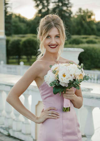 Bridal Fashion. Portrait of young beautiful modern bride with stylish make-up and and hairdo in mermaid style wedding pink dress.の写真素材