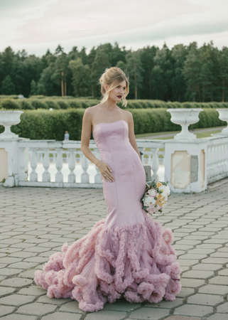 Bridal Fashion. Portrait of young beautiful modern bride with stylish make-up and and hairdo in mermaid style wedding pink dress.の写真素材