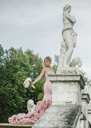 Bridal Fashion. Portrait of young beautiful modern bride with stylish make-up and and hairdo in mermaid style wedding pink dress.の写真素材