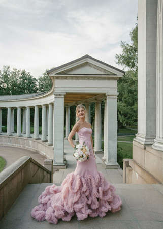 Bridal Fashion. Portrait of young beautiful modern bride with stylish make-up and and hairdo in mermaid style wedding pink dress.の写真素材