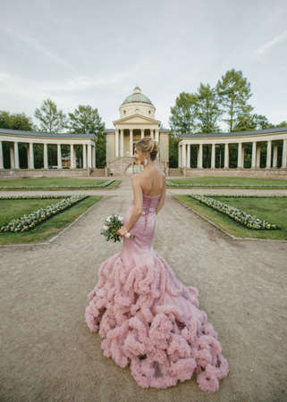 Bridal Fashion. Portrait of young beautiful modern bride with stylish make-up and and hairdo in mermaid style wedding pink dress.の写真素材