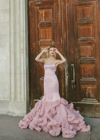 Bridal Fashion. Portrait of young beautiful modern bride with stylish make-up and and hairdo in mermaid style wedding pink dress.の写真素材