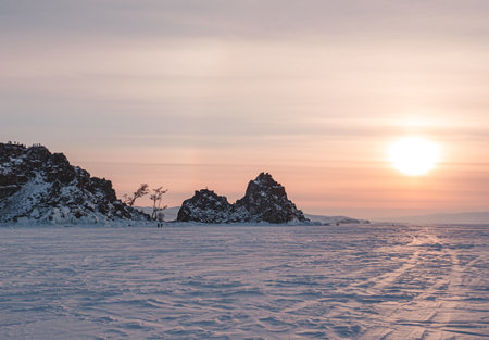 Shamanka rock on Olkhon island on the sunset. Winter landscape of lake Baikal. Famous tourist spot on Baikalの写真素材