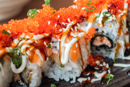 Close up of salmon and tobiko sushi rolls with sesame seeds and green onions.の写真素材