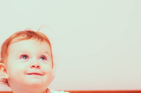 Happy toddler girl smiling, looking up.の写真素材