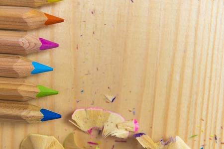 Wooden colorful pencils with sharpening shavings, on wooden tableの写真素材