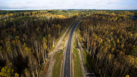 Aerial view of country road through the forest in autumn. drone photographyの写真素材