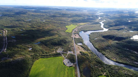 Aerial top view of a country road through a green rural fieldの写真素材