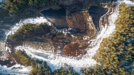 Drone view on wild nature rural forest with lake and snow melting in springの写真素材
