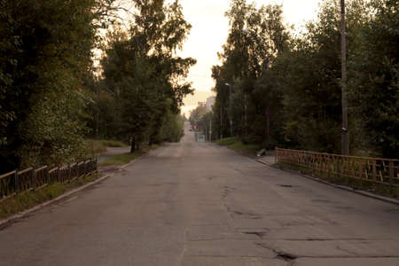 The empty street at night with rural bad asphalt road in summer.の写真素材