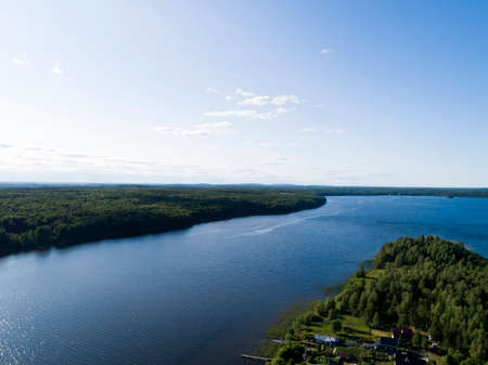 Aerial view on lake shore in summer day with green forestの写真素材