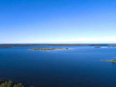 Aerial view on lake shore in summer day with green forestの写真素材