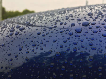 Water drops at blue car paint. Polishing and detailing carsの写真素材
