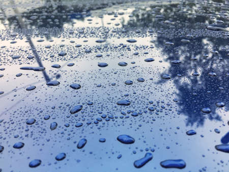 Water drops at blue car paint. Polishing and detailing carsの写真素材