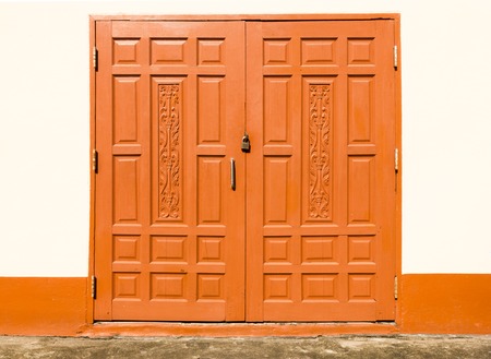 brown wooden door locked with a padlockの写真素材