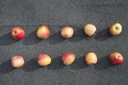 a scattering of red apples on a background of asphaltの写真素材