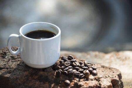 Cup of coffee and coffee beans on a stone background.の写真素材