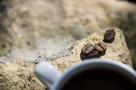 Cup of coffee and coffee beans on a stone background.の写真素材