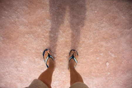 Mens legs close-up on the pink salt lake Sasyk in the Republic of Crimea, Russia. Sunny day...