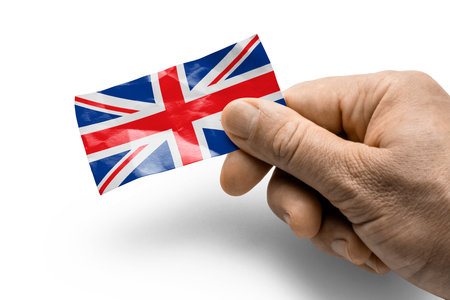 Hand holding a card with a national flag the United Kingdom