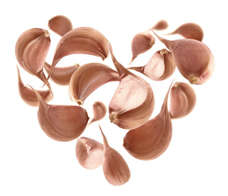 Ripe garlic in the shape of a heart on a white backgroundの写真素材