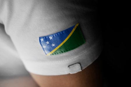 Patch of the national flag of the Solomon Islands on a white t-shirtの写真素材
