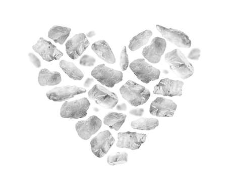 Rock salt close up in the shape of a heart on a white backgroundの写真素材