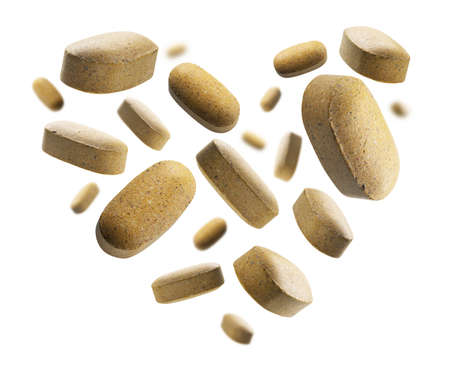 Yellow tablets in the shape of a heart on a white background